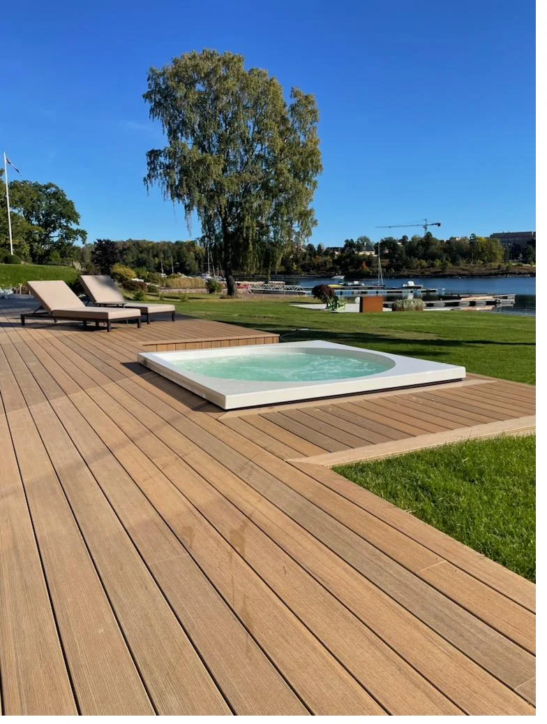 Terrasse i TimberTech Coconut Husk rundt nedfelt boblebad ved sjøen